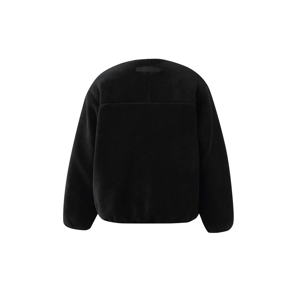 Back of a black fleece jacket, with a yoke seam and small dark tab near the collar.