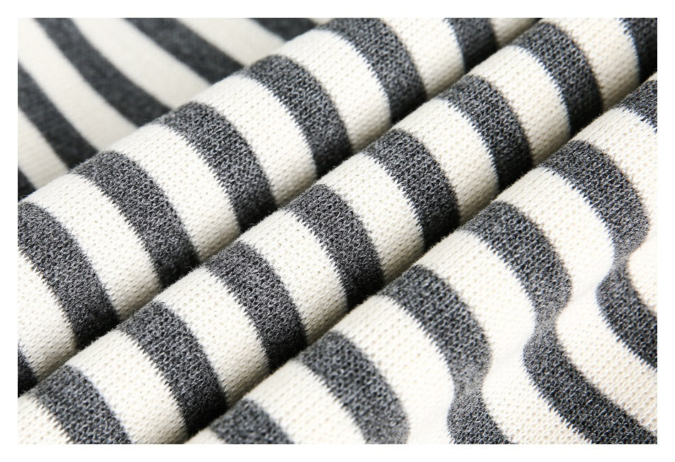 Macro view of soft-looking cream and charcoal striped knit fabric folded into ridges.