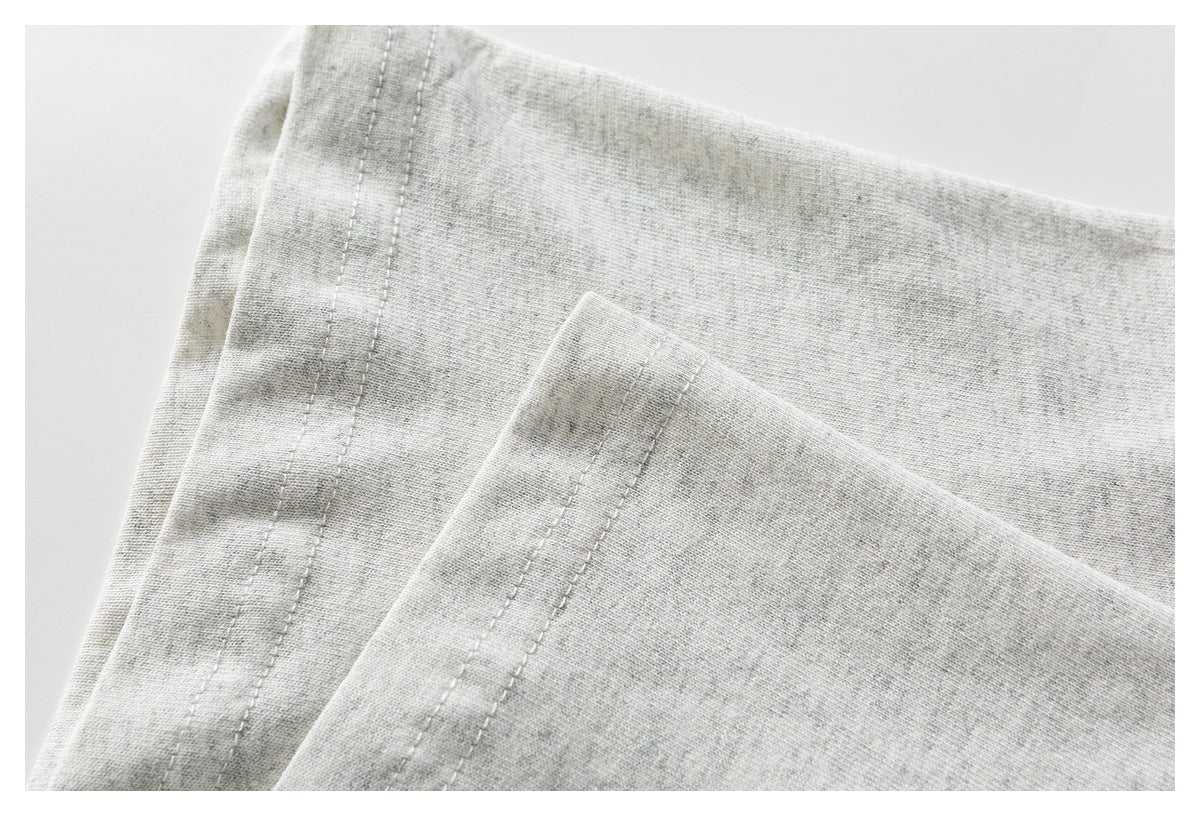 Close-up of heather-gray garment fabric with parallel stitched seams.