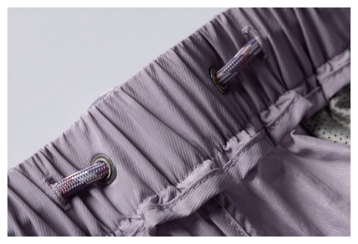 Close-up of a gathered mauve waistband with metal eyelets and a patterned drawcord.