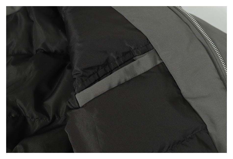 Close-up of the dark lining and interior construction beside the zipper of a gray jacket.