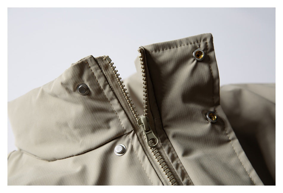 Close-up of a taupe jacket collar with a zipper and metal snap fasteners.