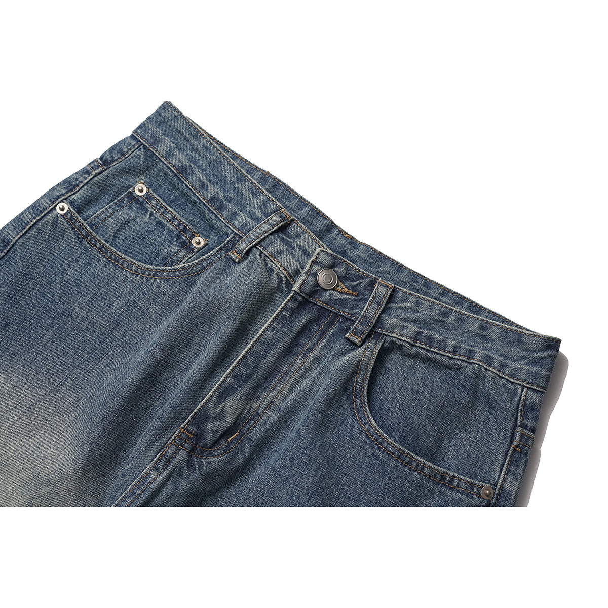 Close-up of blue washed jeans showing the waistband, metal button, belt loops, fly stitching, and front pockets.