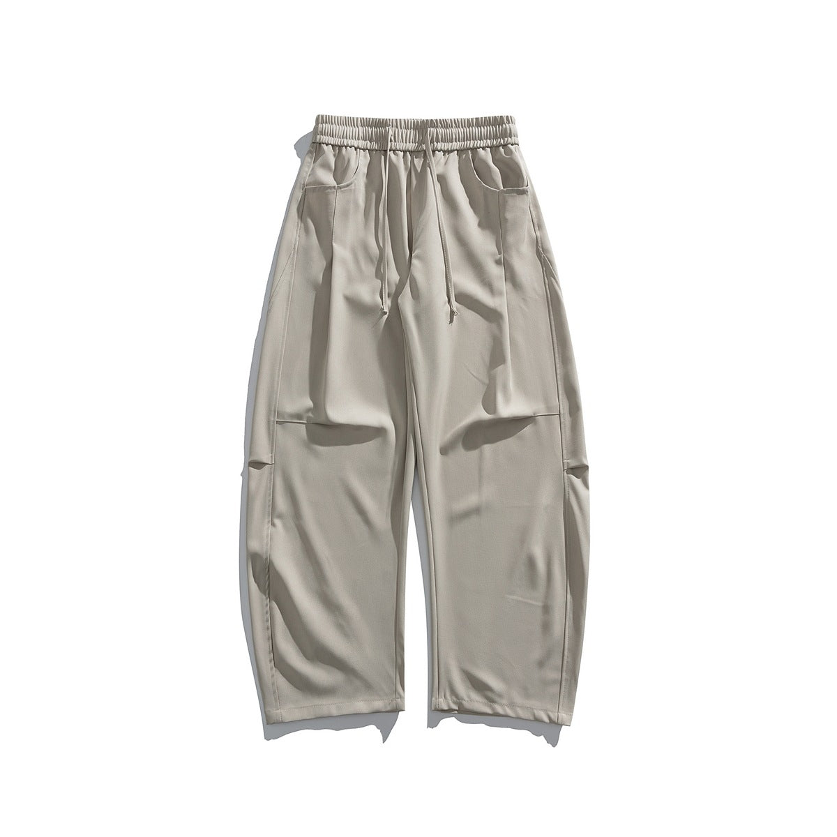 Beige wide-leg drawstring trousers with elastic waist, front pockets and knee seam, flat lay front view