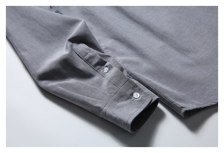 Close-up of the gray shirt's buttoned sleeve cuff and curved hem.