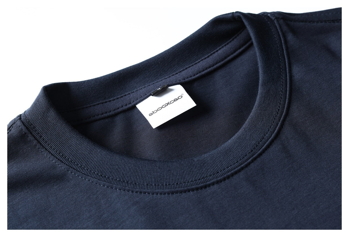 Close-up of a dark navy T-shirt crew neck, ribbed collar, stitching, and white neck label.