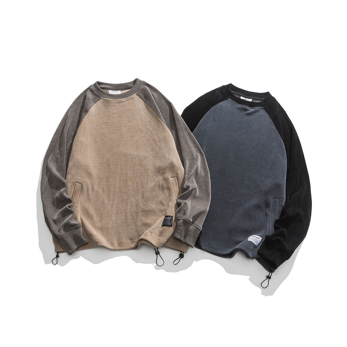 Two raglan sweatshirts laid flat: beige with gray sleeves and charcoal with black sleeves.