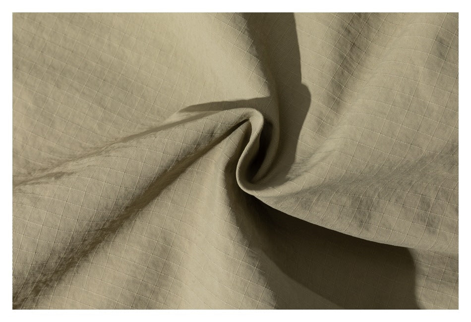 Close-up showing the fine grid texture and folds of khaki fabric.