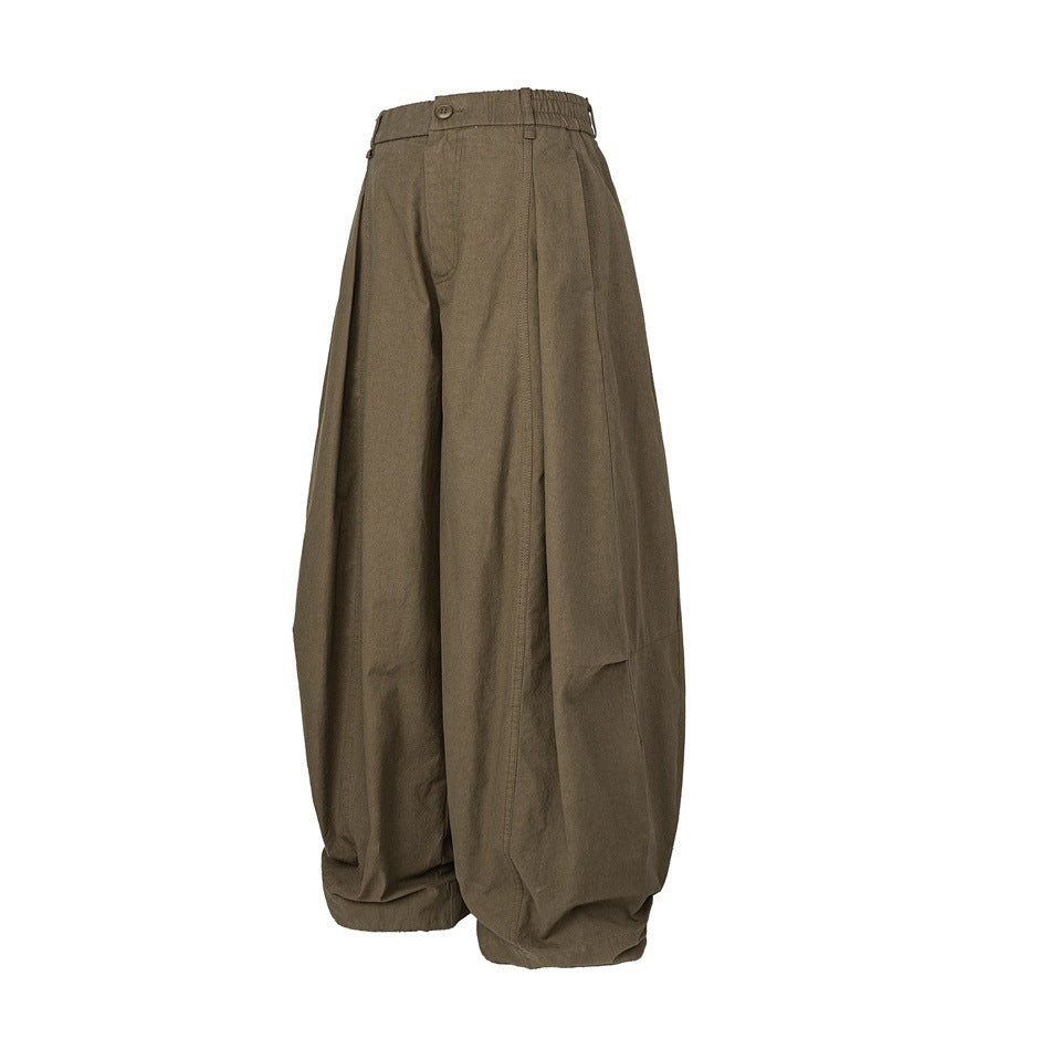 Angled front view of olive-brown wide-leg trousers with a buttoned waistband and side pockets.