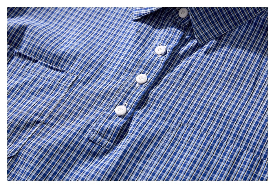 Close-up of a blue checked shirt front with white buttons, collar, and chest pocket.