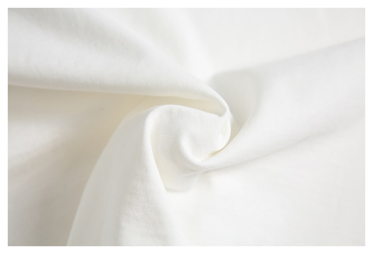 Close-up of white garment fabric gathered into a soft fold.