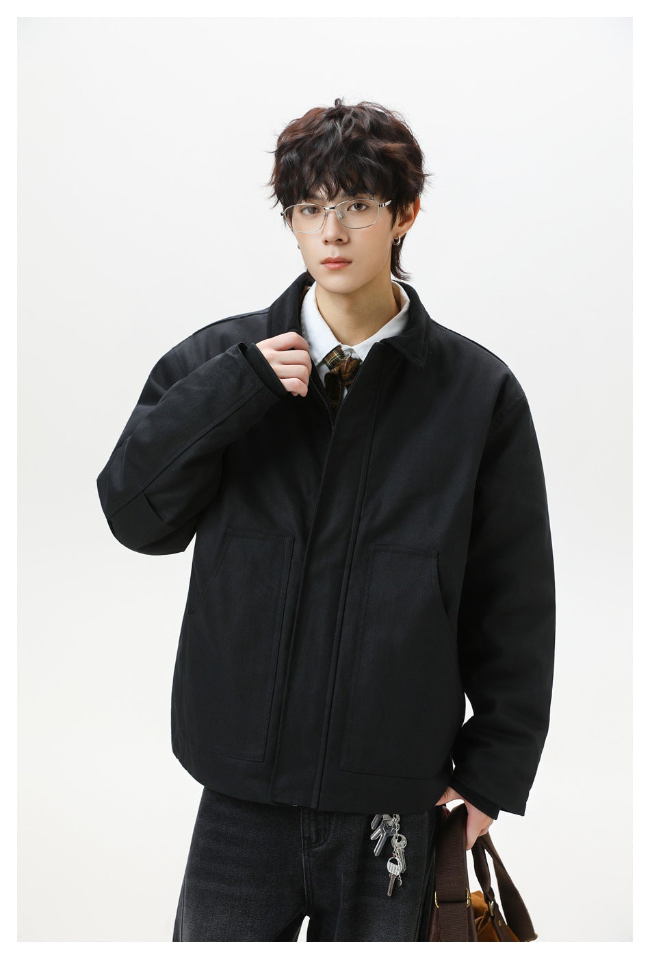 Model wearing a black zip-front jacket with a pointed collar and two large front patch pockets.