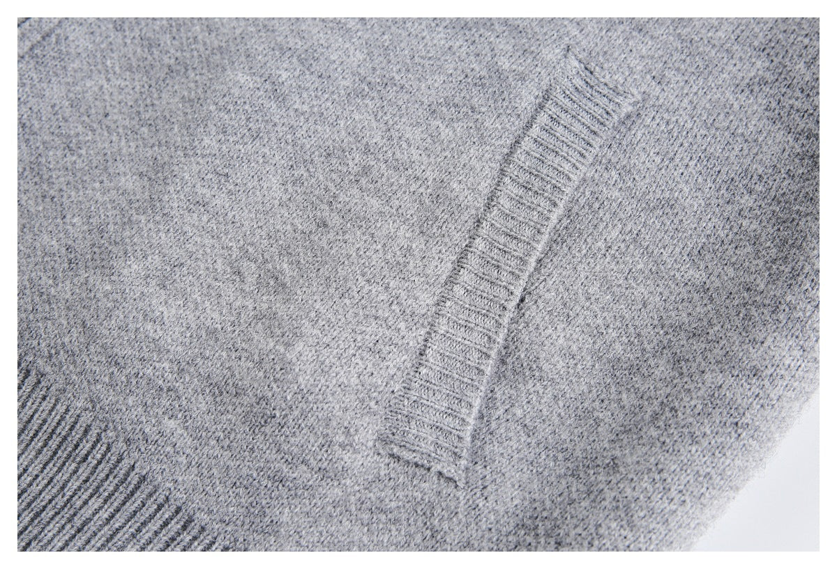 Close-up of gray knit fabric with a narrow ribbed trim and seam.