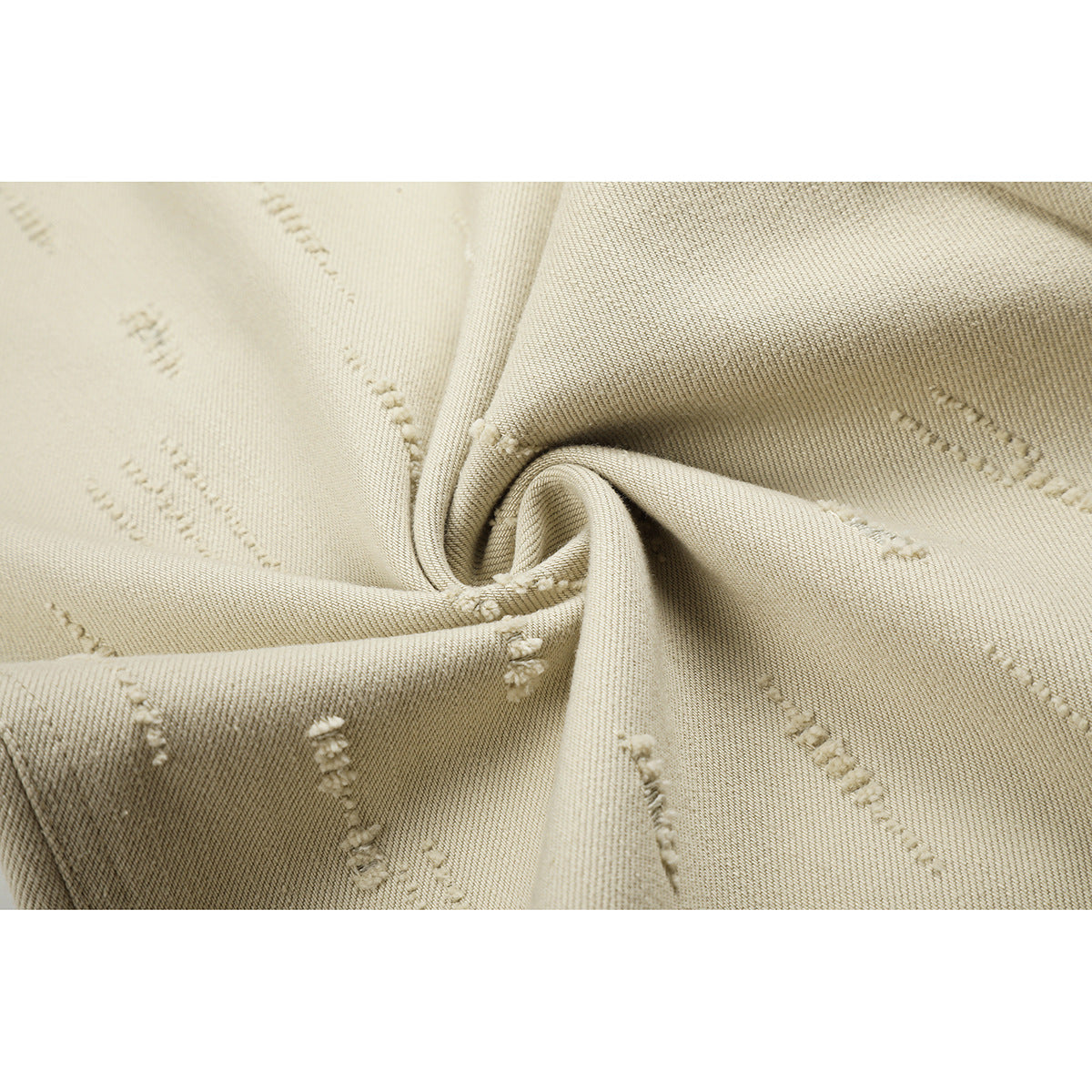 Close-up of light beige fabric with scattered raised linear details and a visible weave.