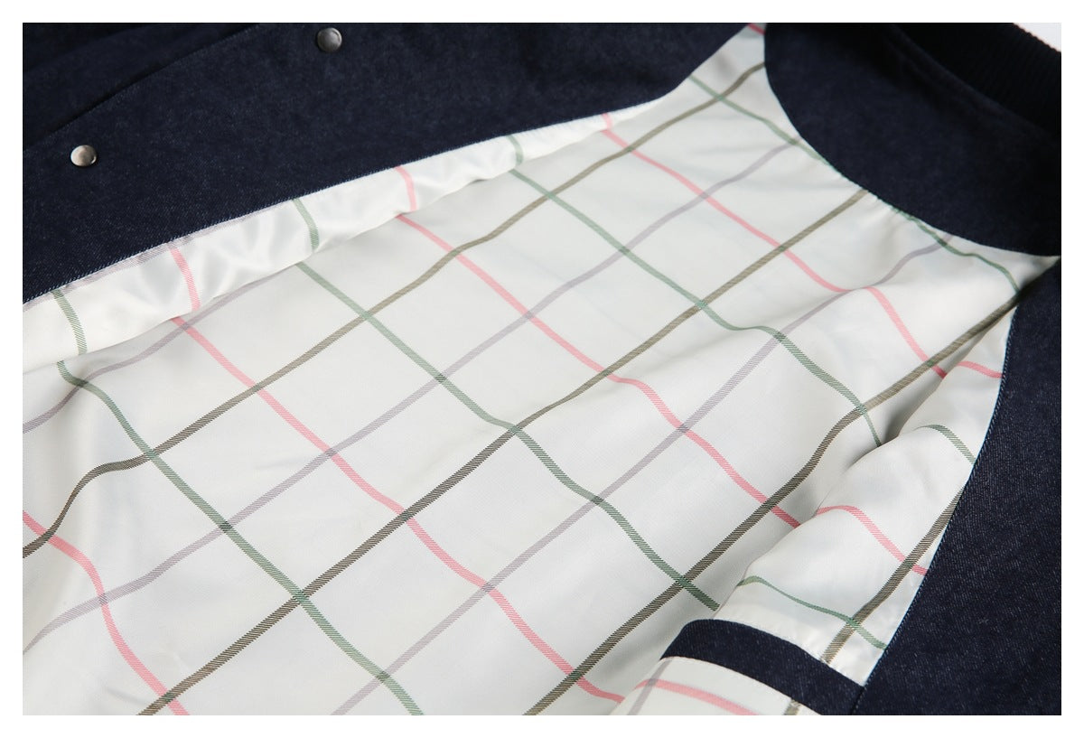 The open interior of a dark indigo garment reveals cream lining with multicolor plaid stripes.