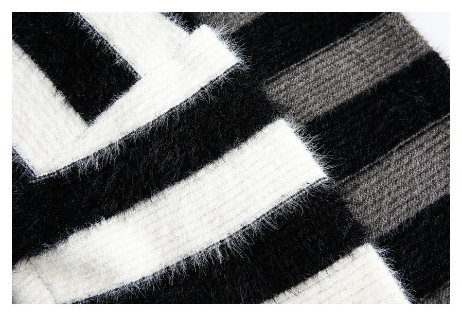 Extreme close-up of fuzzy black knit with ivory and gray horizontal stripe sections.