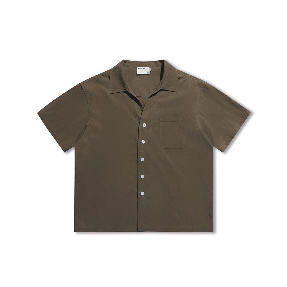 Brown short-sleeve button-front shirt with camp collar and chest pocket, flat lay front view