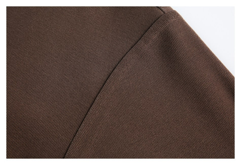 Close-up of a curved seam on brown rib-knit fabric.
