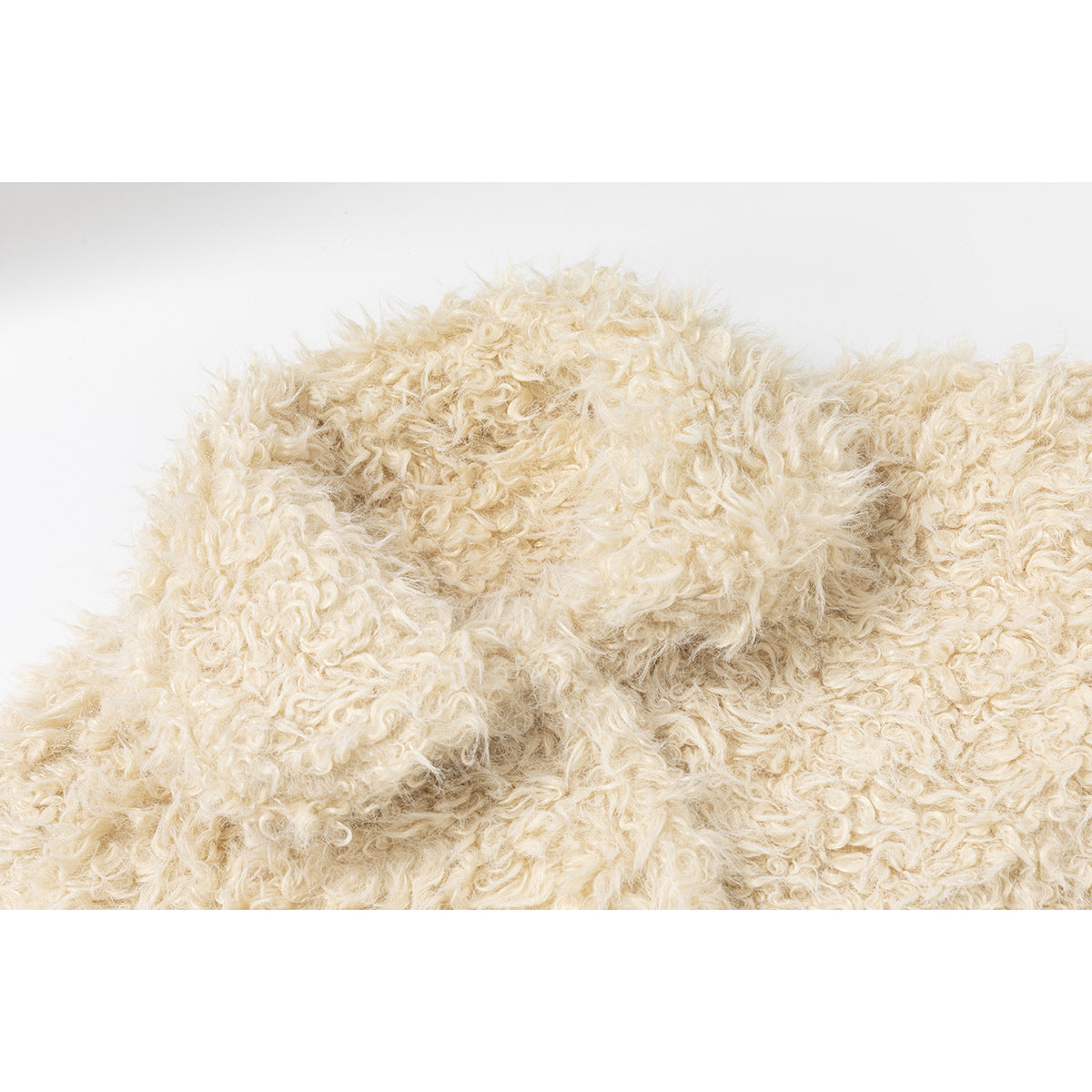 Close-up of dense, curly cream-colored pile fabric.