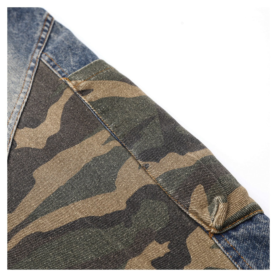 Close-up of a camouflage fabric section joined to blue denim with visible stitching.