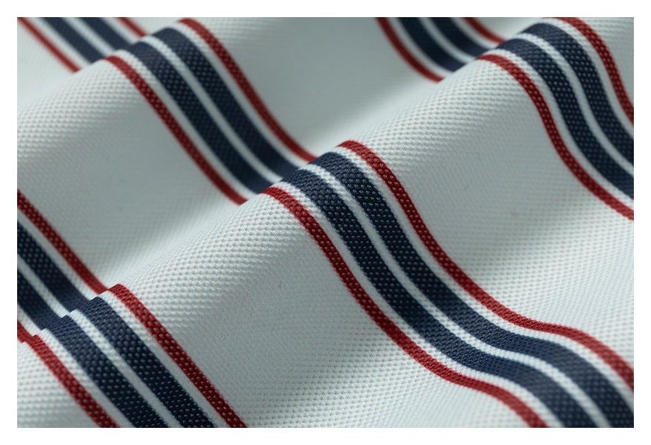 Macro view of pale textured fabric with red and navy stripes.