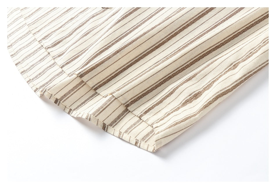 Close-up of a stitched hem on cream fabric patterned with narrow brown stripes.