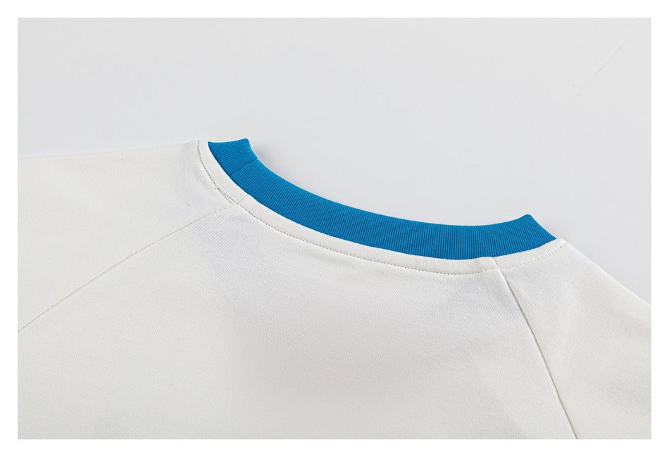 Close-up of a white shirt's back neckline with bright blue ribbed collar trim and shoulder seams.