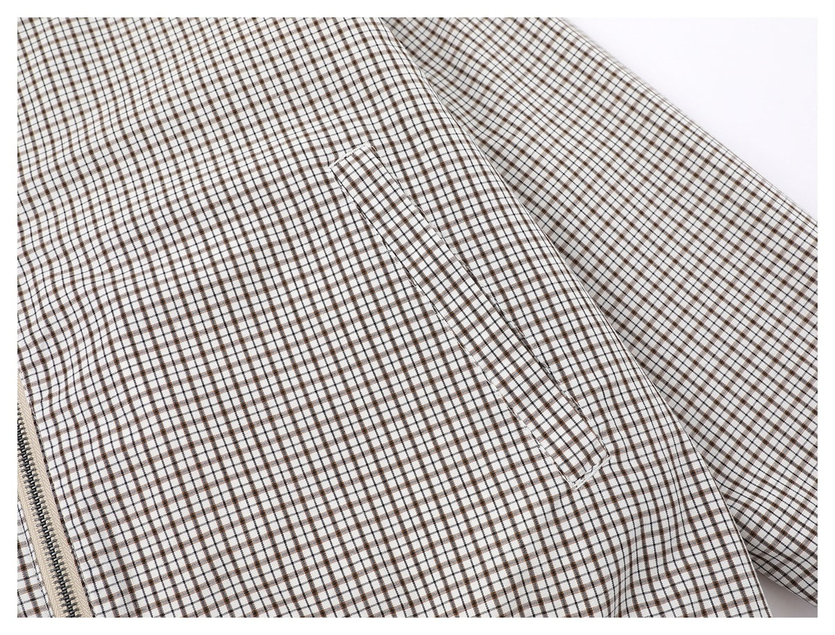 Close-up of the white and brown checked jacket fabric and a narrow side pocket opening.