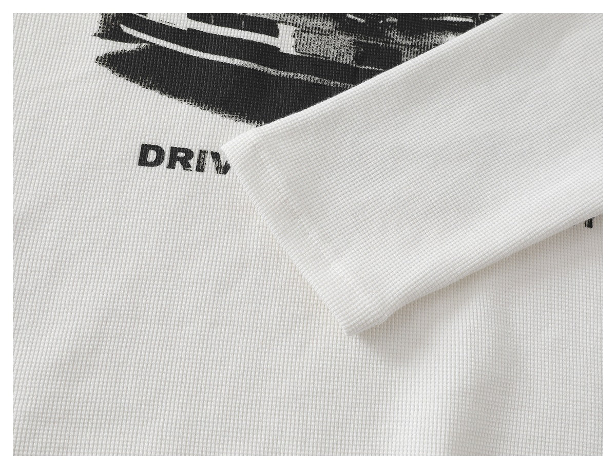Close-up of a white waffle-knit shirt sleeve laid across part of its black chest graphic.