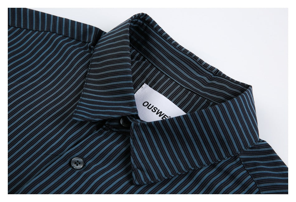 Close-up of the pinstriped shirt collar, buttons, and sewn neck label.
