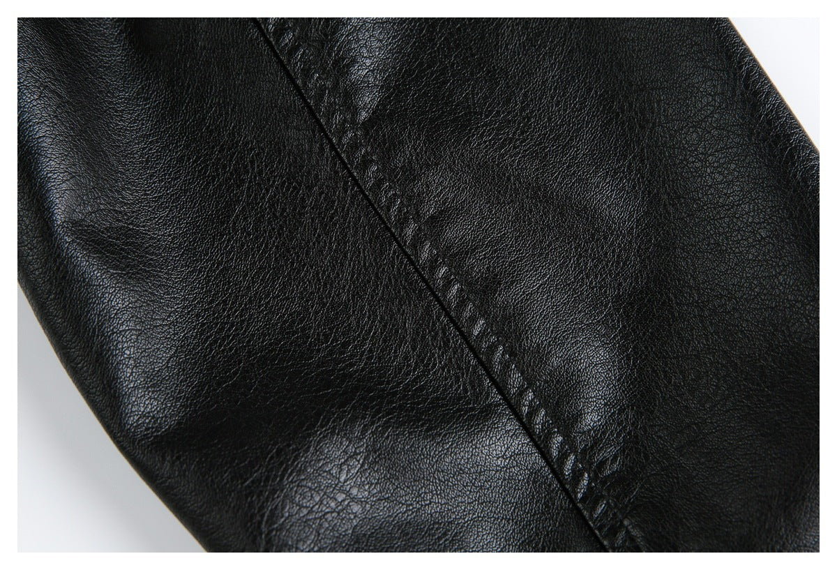 Close-up of black pebbled jacket material with a diagonal stitched seam.
