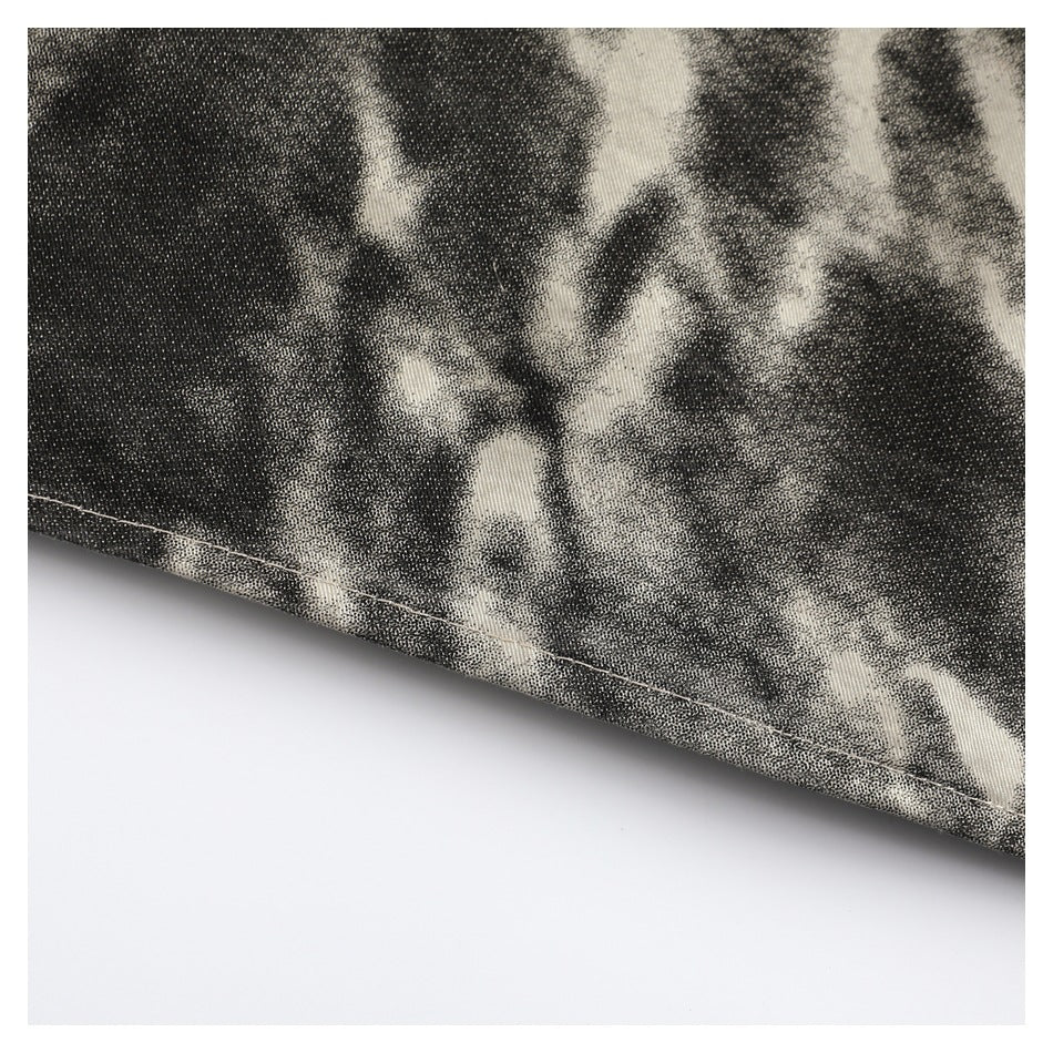 Close-up of the stitched hem on a black and cream abstract-patterned garment.