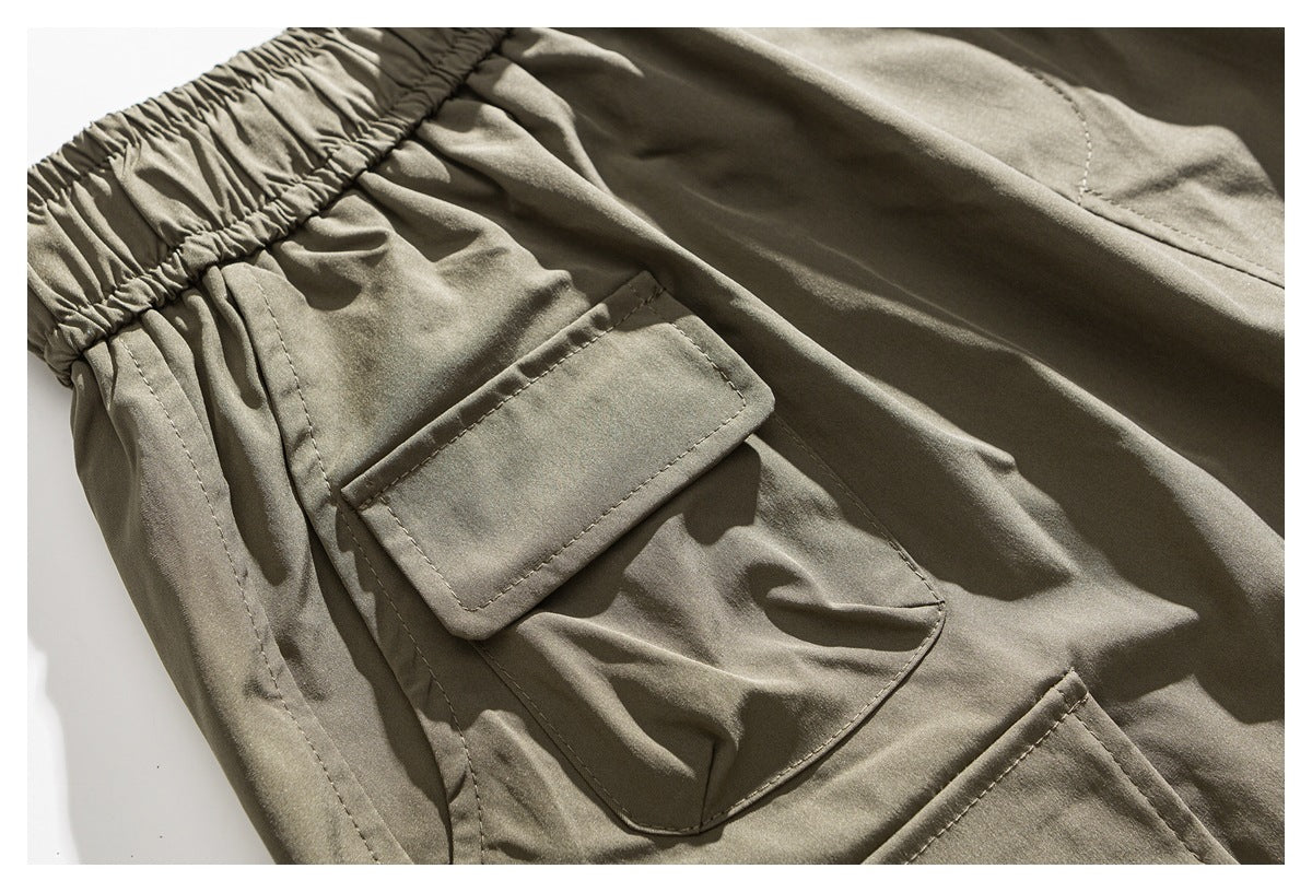 Close-up of a khaki trouser cargo pocket with a flap and visible stitching.