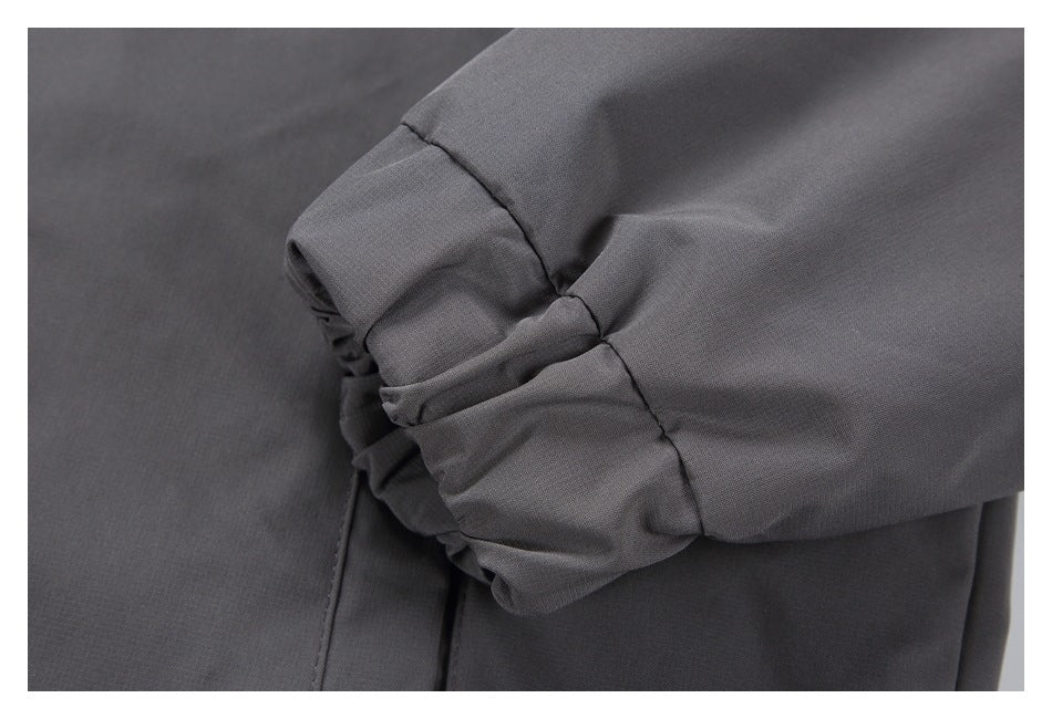 Close-up of a dark gray sleeve cuff with gathered elastic and seam details.