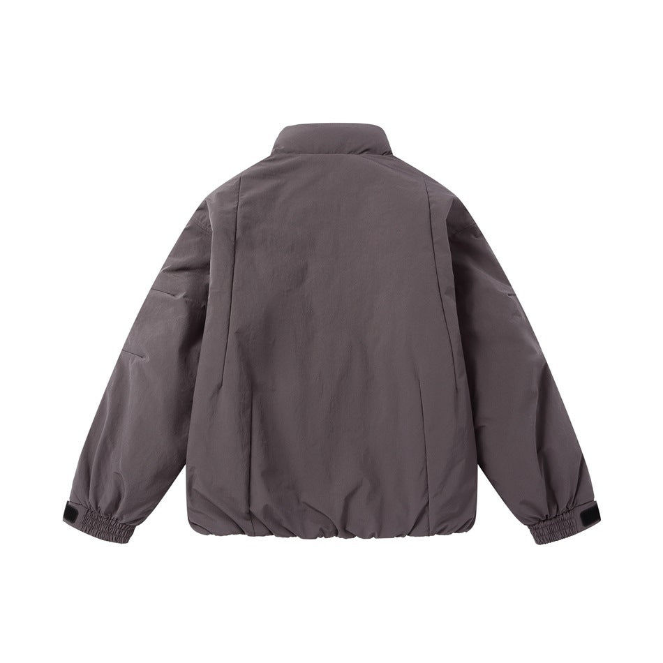 Back view of a dark charcoal-gray jacket with a high collar, raglan sleeves, and elasticated cuffs and hem.