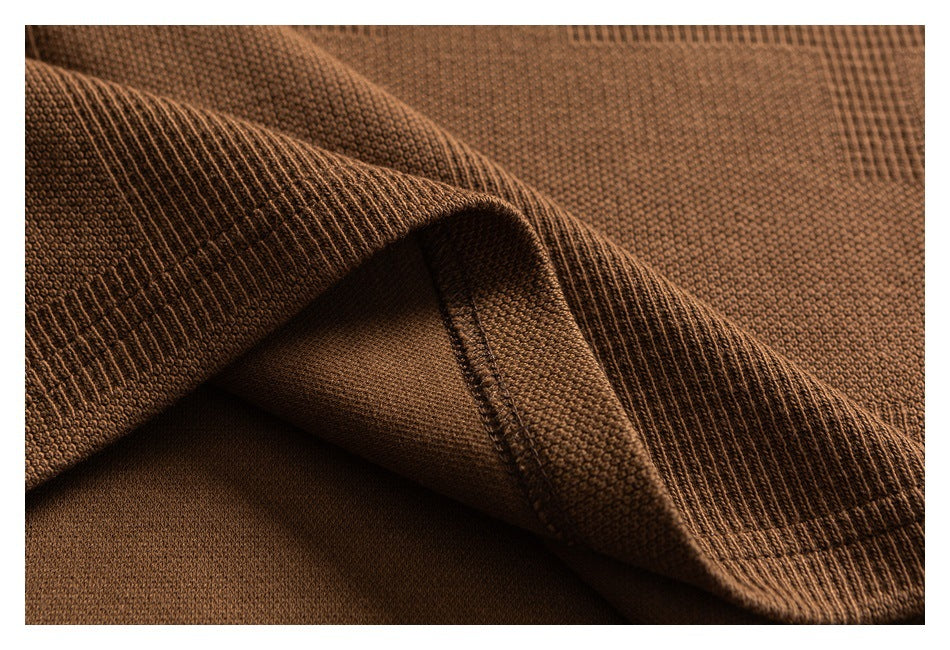 Close-up of brown knit fabric folded back to show the ribbed edge and underside.