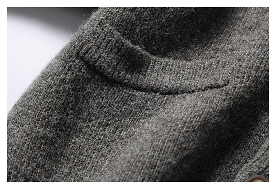 Close-up of a charcoal gray knit cardigan's flap pocket and textured knit.