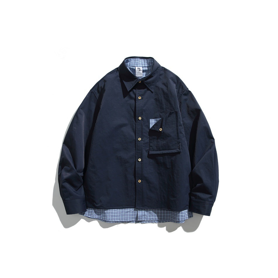 Navy blue long-sleeve button-up shirt with flap chest pocket and gingham underlayer at collar and hem, flat lay