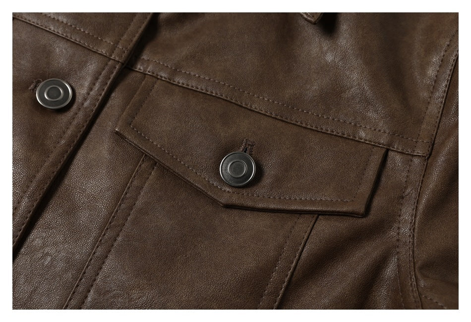 Close-up of a dark brown jacket's snap-fastened flap pocket and stitched seams.