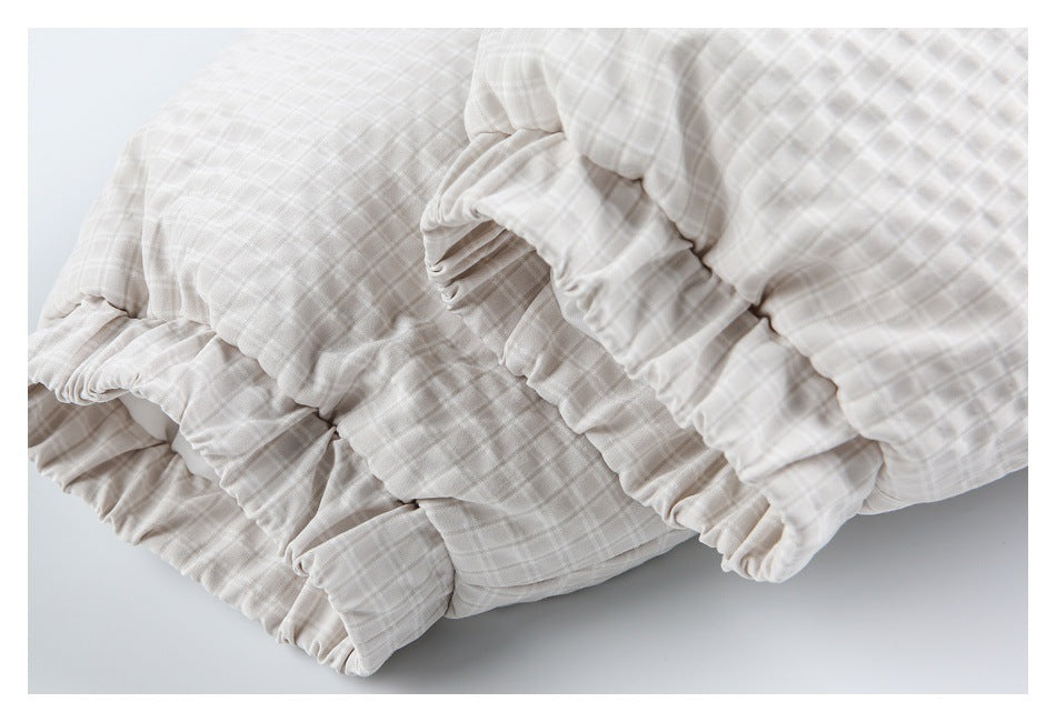 Close-up of gathered elastic trim on a white and pale gray check garment.