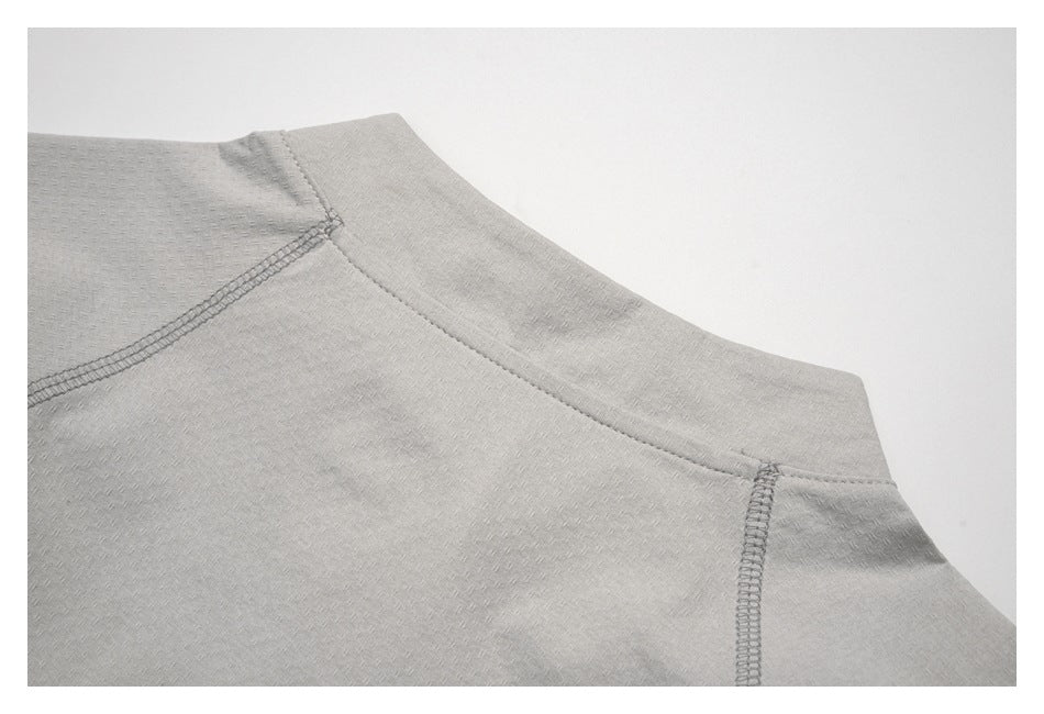Close-up of a light gray shirt neckline and shoulder seams.