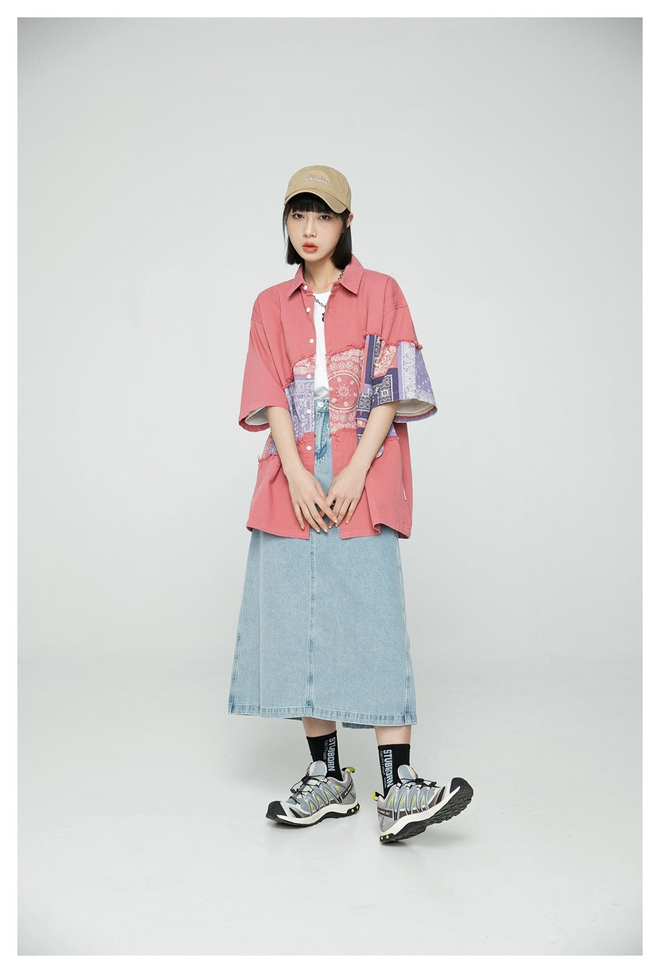 Model wearing an oversized coral shirt with paisley patchwork panels, shown from the front.