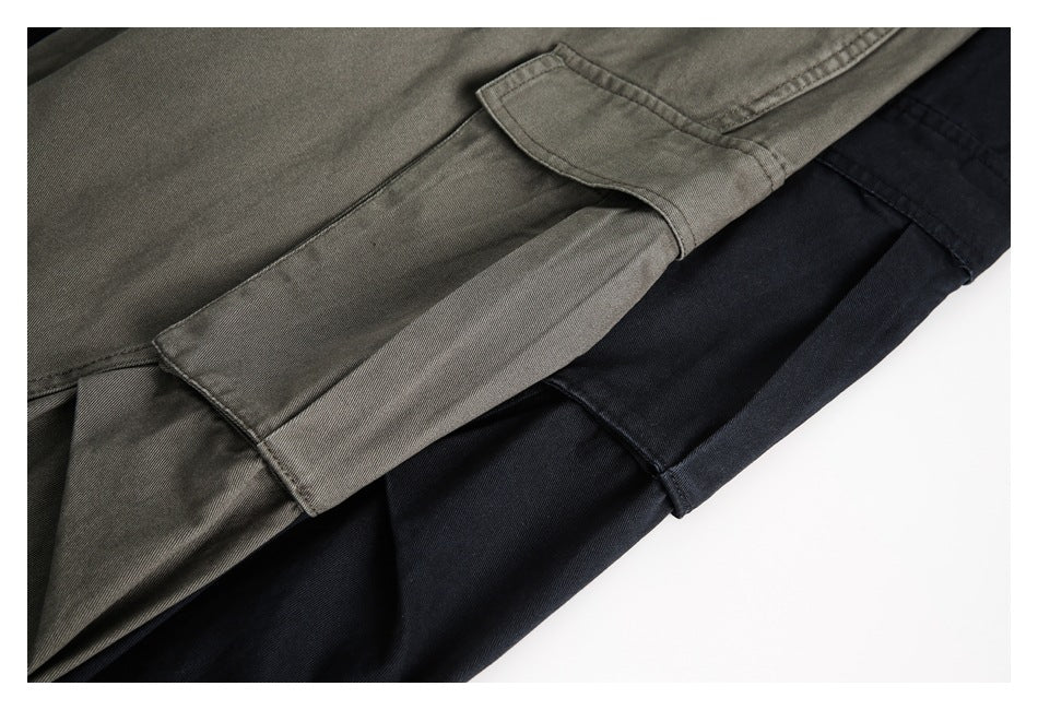 Close-up of olive-gray and black cargo pants overlapping, highlighting the flap thigh pockets and stitching.