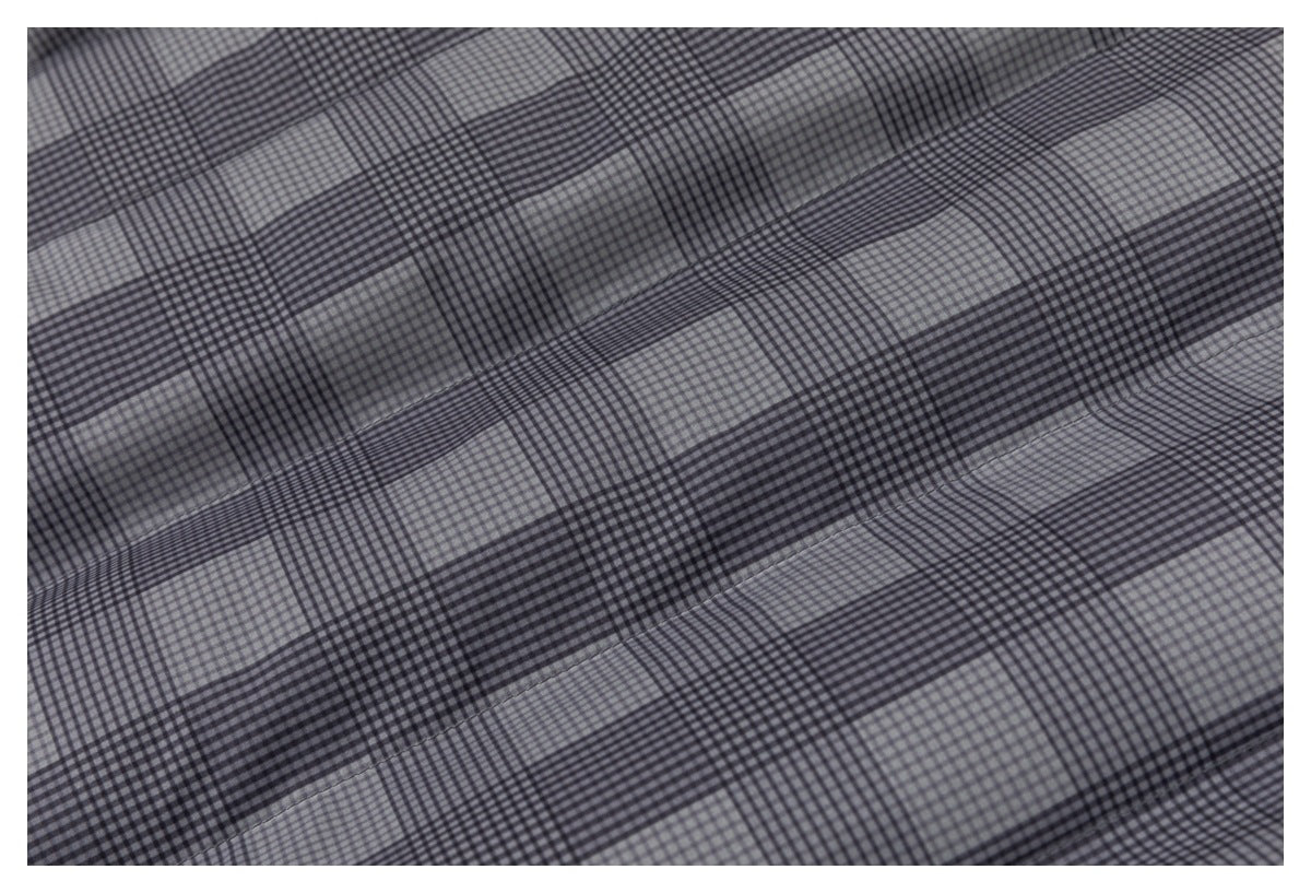 Close-up of gray and black checked fabric with broad alternating plaid bands and visible seams.