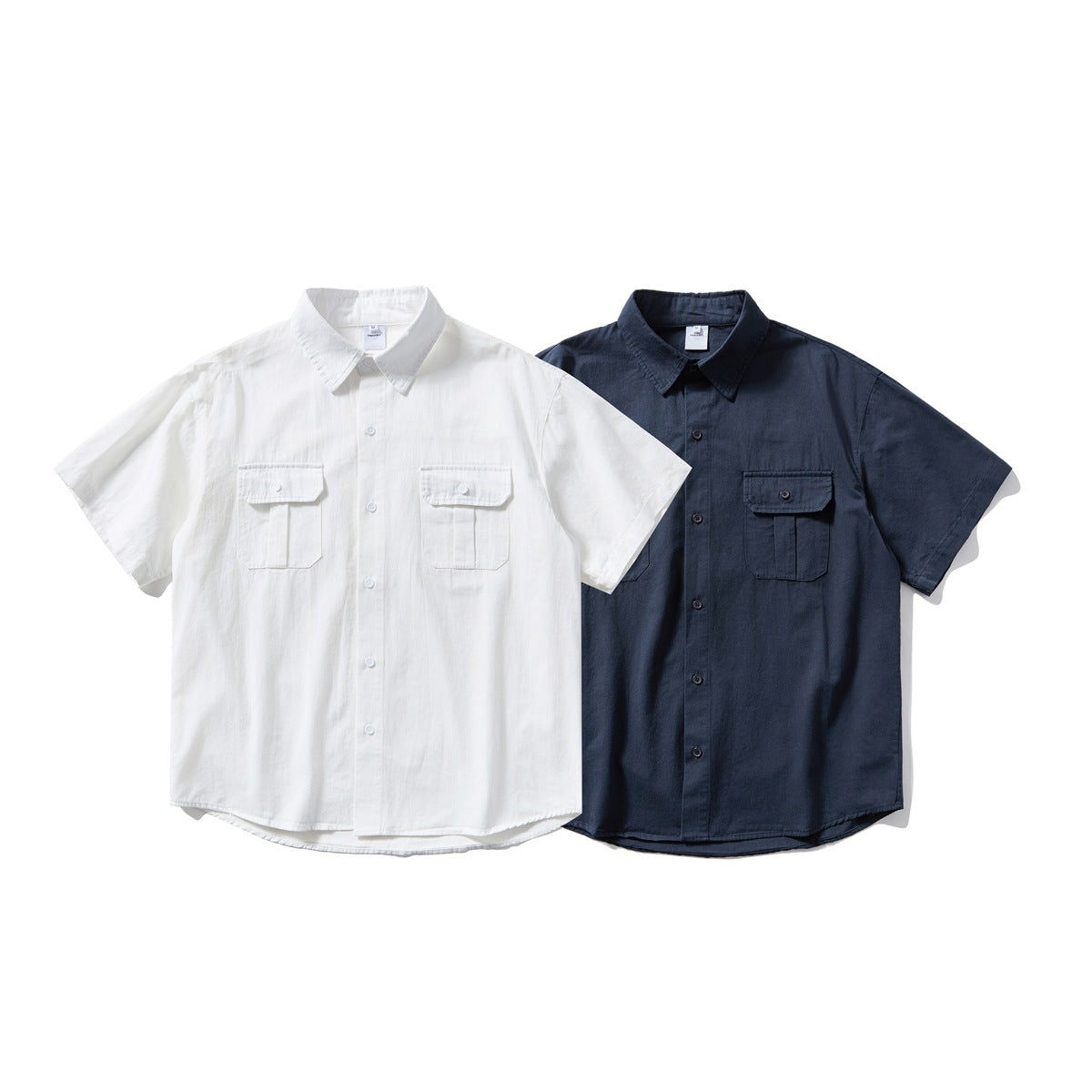 Two short-sleeve button-up shirts shown from the front, one white and one dark navy, each with two flap chest pockets.