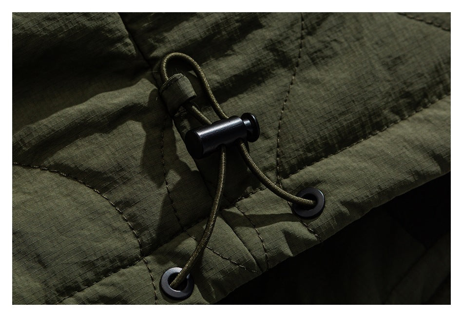 Close-up of an olive-green jacket's adjustable hem drawcord, eyelets, and toggle.