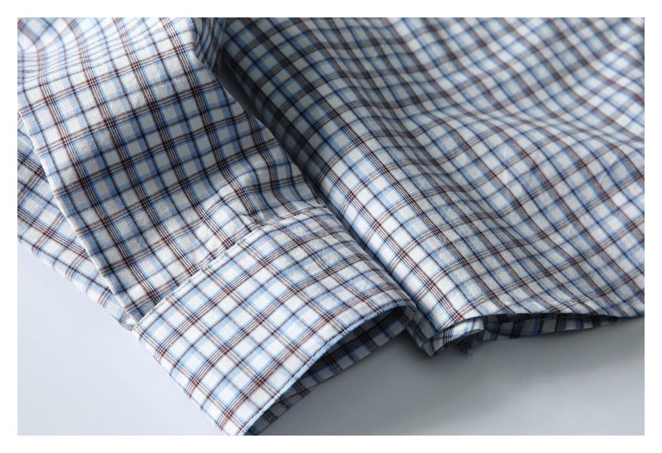 Close-up of the blue-and-brown plaid shirt's folded lower edge and stitched hem.