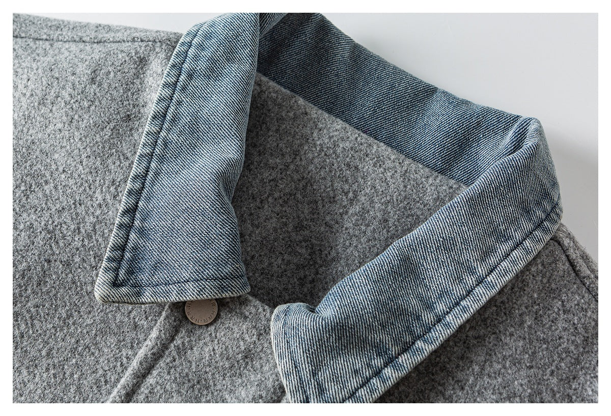 Close-up of a gray textured coat collar with blue denim-like inner facing and a round button.
