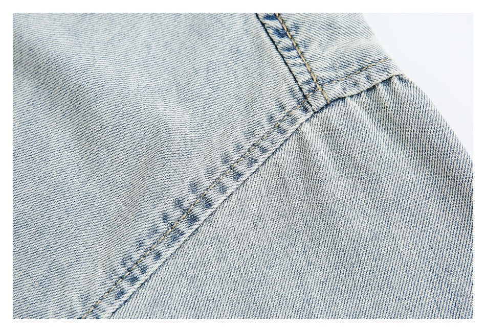 Close-up of intersecting seams on pale washed denim.