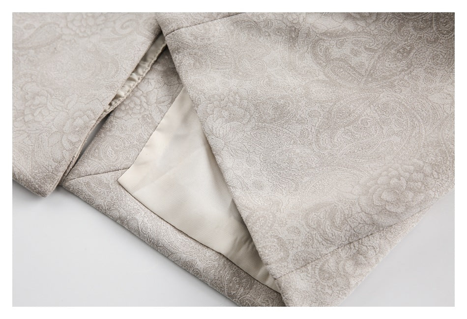 Close-up of the pale beige paisley blazer hem, showing cream lining and finished seams.